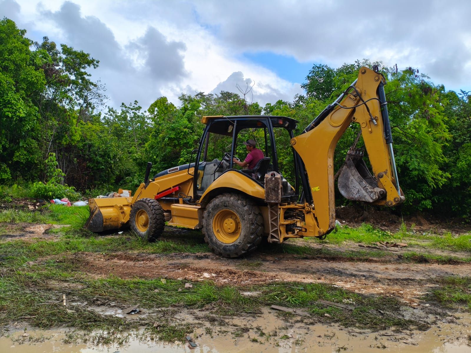 Retroexcavadora trabajando en la limpieza de un terreno